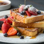 French toast topped with fresh berries and maple syrup.